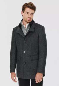 Czarny, ciemnoszary płaszcz wełniany z zapięciem na guziki, z wyprofilowanym kołnierzem i dwoma przednimi kieszeniami. Charakteryzuje się miękką fakturą i dopasowanym krojem.