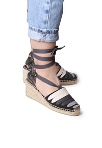 Sandali con zeppa espadrille caratterizzati da una suola in juta intrecciata, fasce in tessuto multicolore in grigio e crema, con lacci alla caviglia e una punta triangolare.