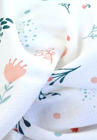 Katoenen stof met bloemenpatroon in koraal, groen en blauw op een witte achtergrond, met een gestructureerde, zachte afwerking.