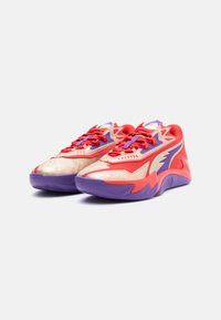 Czerwono-kremowe buty sportowe z purpurowymi akcentami i podeszwą. Posiadają teksturowane powierzchnie oraz wyraziste, kanciaste elementy designu. Zapięcie na sznurowadła.