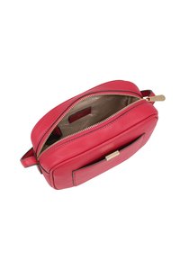 Rode leren crossbody tas met een ritssluiting aan de bovenkant, gouden hardware en een voorvak. Het interieur heeft een gladde beige voering.