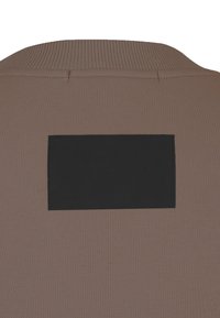 Brązowy top sportowy z teksturowanej tkaniny. Posiada prążkowany kołnierzyk oraz czarną prostokątną metkę z tyłu.