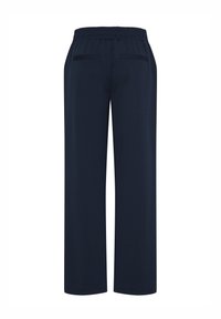 Pantalon bleu marine à jambes droites avec ceinture élastique et deux poches passepoilées à l'arrière, vu de dos.