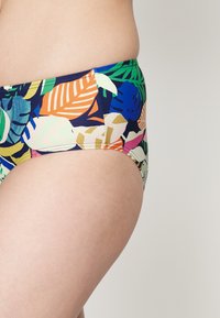 Fundo de biquíni com um padrão de folhas coloridas em laranja, verde, azul e rosa sobre um fundo azul-marinho; tecido elástico; design de cintura baixa.