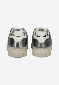 Baskets argentées métalliques et beige avec une texture douce, accents blancs, et une semelle en caoutchouc striée avec un design arrière distinctif.