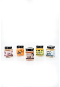 Cinque barattoli di scrub per il corpo, caratterizzati da colori e etichette diverse. I barattoli hanno coperchi neri, con design distintivi e nomi dei prodotti esposti in modo evidente.