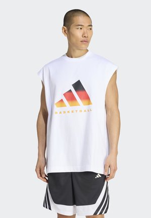 Uomo che indossa una maglietta da basket senza maniche bianca con un logo tricolore e pantaloncini sportivi bianchi e neri, che guarda di lato.