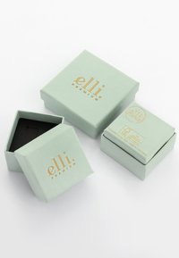 Grüne Karton-Geschenkkisten mit goldener Schrift. Eine geöffnete Box zeigt ein schwarzes Interieur, alle mit einem minimalistischen Design.