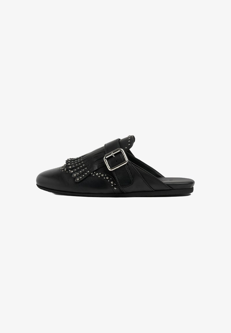 Scarpe slip-on in pelle nera con cinturino a fibbia, decorazioni con borchie e un design con frange sulla parte superiore. Suola piatta con una finitura liscia.