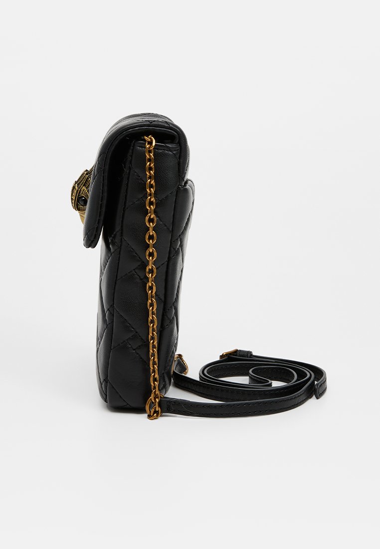 Bolso de mano de cuero negro acolchado con acento de cadena dorada y correa ajustable, que presenta un cierre de solapa y forma redondeada.