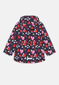 Veste bleu marine avec un motif en forme de cœur en rouge, rose et blanc. Elle a une capuche, une taille élastique et des manches longues avec des poignets élastiques.
