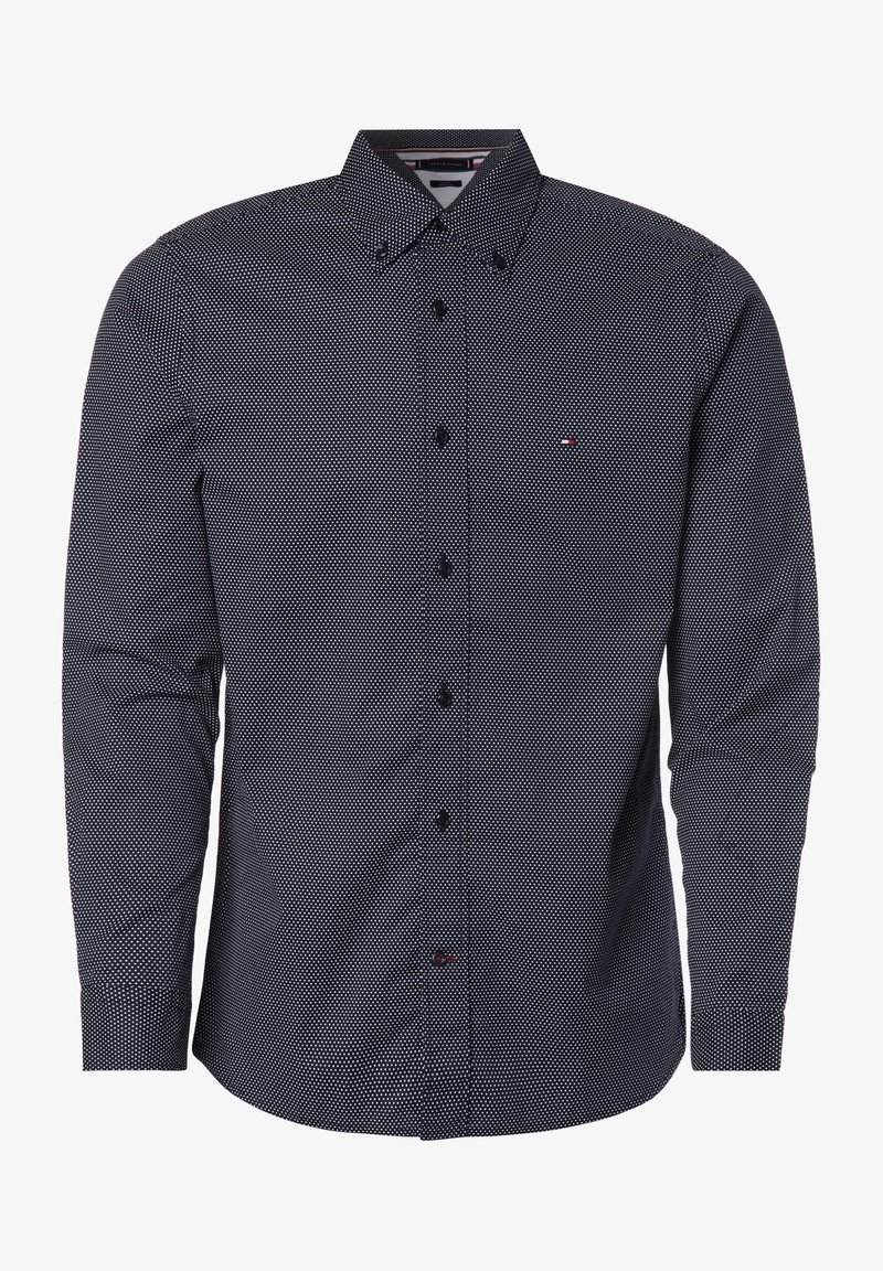 Granatowa koszula zapinana na guziki z małym białym wzorem w kropki, z kołnierzykiem w kształcie ostrego szpica i długimi rękawami, wykonana z lekkiej tkaniny.