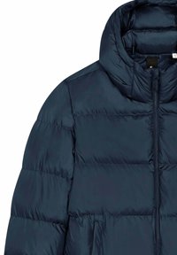 Giacca imbottita blu navy con collo alto, chiusura con zip completa e tasche laterali. Texture liscia con sezioni trapuntate per isolamento.