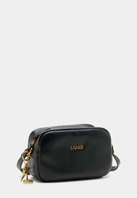 Borsa a tracolla in pelle nera con finitura testurizzata, hardware dorato e logo dorato. Presenta una chiusura con zip e un charm removibile.