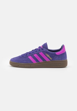 Fioletowe zamszowe buty sportowe Adidas Spezial z różowymi paskami, brązową fakturowaną podeszwą i złotymi literami "Spezial" po boku.