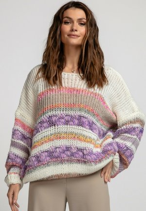 Gruby sweter prążkowany w kremowym kolorze z poziomymi paskami. Paski mają kolory: fioletowy, różowy, pomarańczowy i zielony. Luźny krój z szerokimi rękawami.