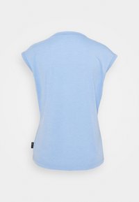 Ljusblå kortärmad t-shirt med rund halsringning och mjukt tyg. Har en subtil böjd nederkant och en liten varumärkestagg på sidan.