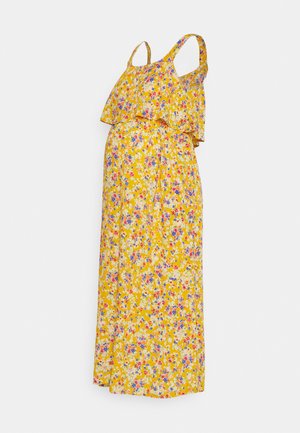 Vestido maxi amarelo florido com alças finas, topo em camadas com babados e um corte solto. Apresenta pequenos padrões de flores azuis, rosas e brancas.