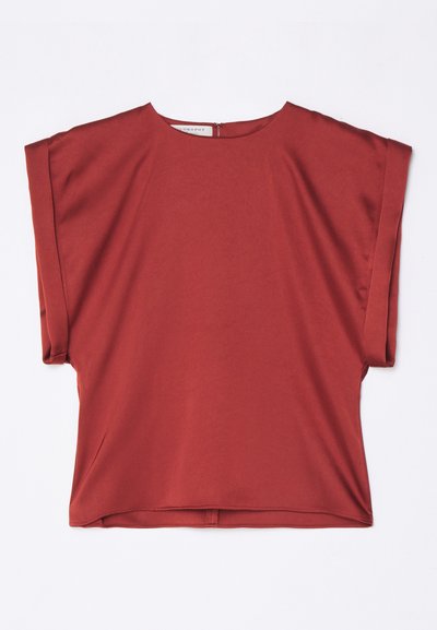 Top rosso a maniche corte, realizzato in tessuto morbido, con scollatura rotonda e vestibilità ampia. Presenta una cerniera sul retro e un design a spalla cadente.