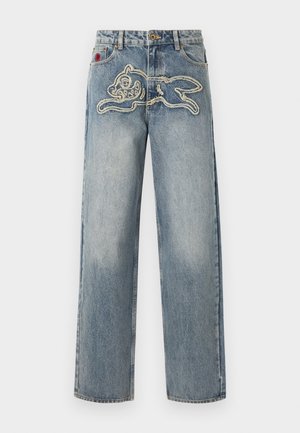 Τζιν με φαρδιά γραμμή και κεντητό περίγραμμα ενός κουνελιού που πηδά στην περιοχή του μπροστινού μηρού.