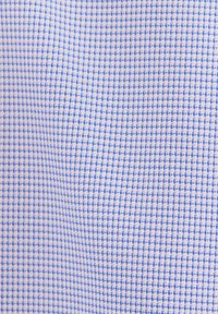 Hellblauer und weißer Vichykaro-Stoff mit kleinem kariertem Muster, der Textur- und Webdetails zeigt.