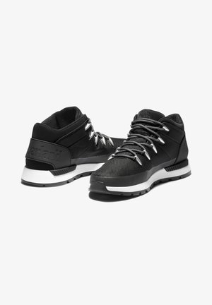 Zapatillas deportivas negras con una parte superior texturizada, cordones plateados y una media suela blanca acolchada. Presenta un logo en el talón y una suela de goma duradera.