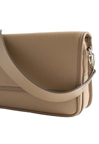 Beżowa torba skórzana o teksturowanej powierzchni, z płaskim designem, długim paskiem i srebrnym zapięciem na boku.