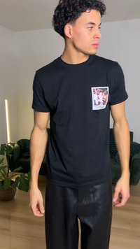 Tricou negru din bumbac, cu gât rotund, având un design cu buzunar dreptunghiular și o imprimare colorată cu fotografie. Combinat cu pantaloni negri.