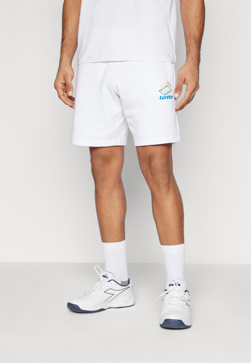 Hvide atletiske shorts med Lotto-logo i blå og gul, parret med hvide sokker og sneakers med marineblå accenter. Glat stofstruktur.