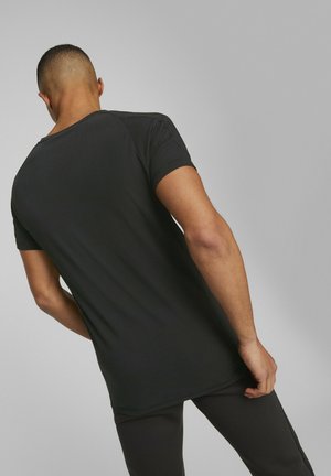 Camiseta negra de manga corta con una textura suave, que presenta un cuello redondeado y un dobladillo trasero ligeramente más largo.