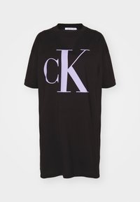 Czarny bawełniany t-shirt z krótkim rękawem, z dużym jasnofioletowym graficznym napisem 'cK' z przodu. Design z okrągłym dekoltem i luźnym krojem.