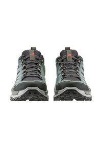 Dunkelgrüne Wanderschuhe mit grauem Mesh, verstärktem schwarzen Gummi-Zehenschutz, metallischen Schnürsenkelakzenten und dicken, strukturierten Sohlen.