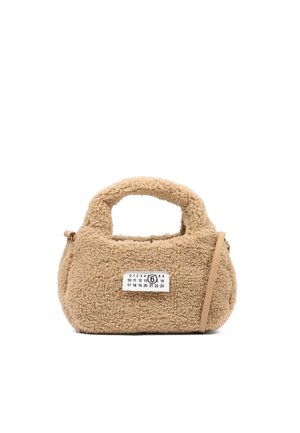Piccola borsa beige in pelliccia sintetica teddy con manico corto, tracolla in pelle e etichetta bianca con numeri neri.