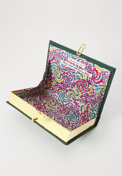 Väike avatud käekott rohelise kangast välispinnaga, kuldse lukuga ja värvilise lillemustriga sisemusega, millel on silt "kästi valmistatud Itaalias".