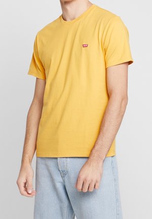 Gelbes Baumwoll-T-Shirt mit Rundhalsausschnitt und kurzen Ärmeln, mit einem kleinen roten Levi's-Logo auf der linken Brust.