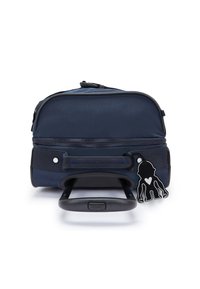 Zaino navy con ruote, manico retrattile, compartimenti con doppia zip e un'etichetta nera a forma di chiave con silhouette di scimmia e cuore.