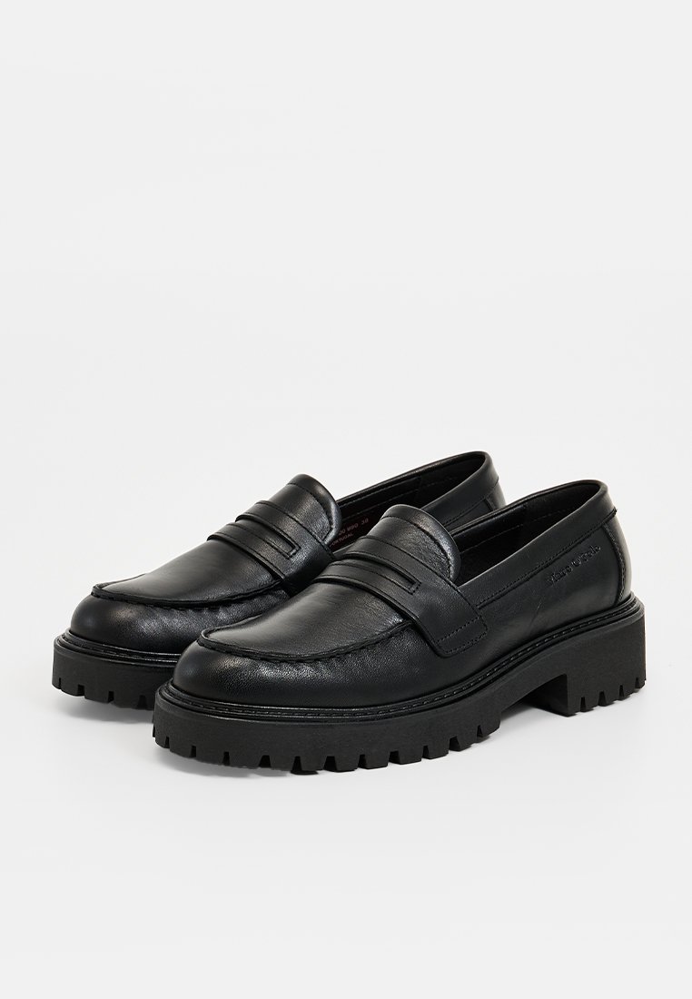 Schwarze Lederloafer mit einer klobigen, geriffelten Sohle. Mit einem Riemendetail über dem Spann. Glatte Textur, lässiges Design und Schlupfstil.