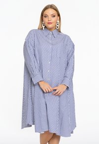 Blau-weiß gestreiftes oversized Hemdkleid, lange Ärmel, Knopfleiste vorne, Brusttasche, leichtes Material, lockere Passform, abgerundetem Saum.