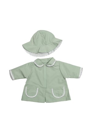 Veste bébé vert clair avec poches frontales et chapeau à large bord assorti, tous deux bordés d’un tissu blanc à pois noirs.