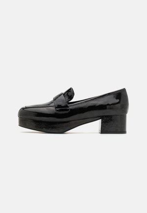 Black patent leather loafers with a square toe, a low block heel, and a decorative strap across the instep. Smooth, shiny finish.