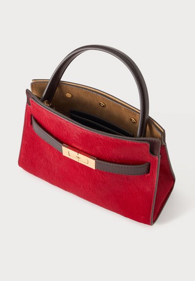 Sac à main rectangulaire rouge avec poignée et bandoulière marron foncé, fermoir doré, et ouverture supérieure laissant voir la doublure intérieure et les poches.