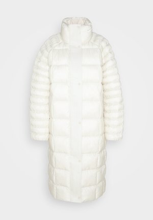 Balta pūkaina jaka ar augstu apkakli, quilted tekstūru, spiedpogu aizdari un vidēju garumu. Gluda auduma ar pūkainu, izolētu izskatu.