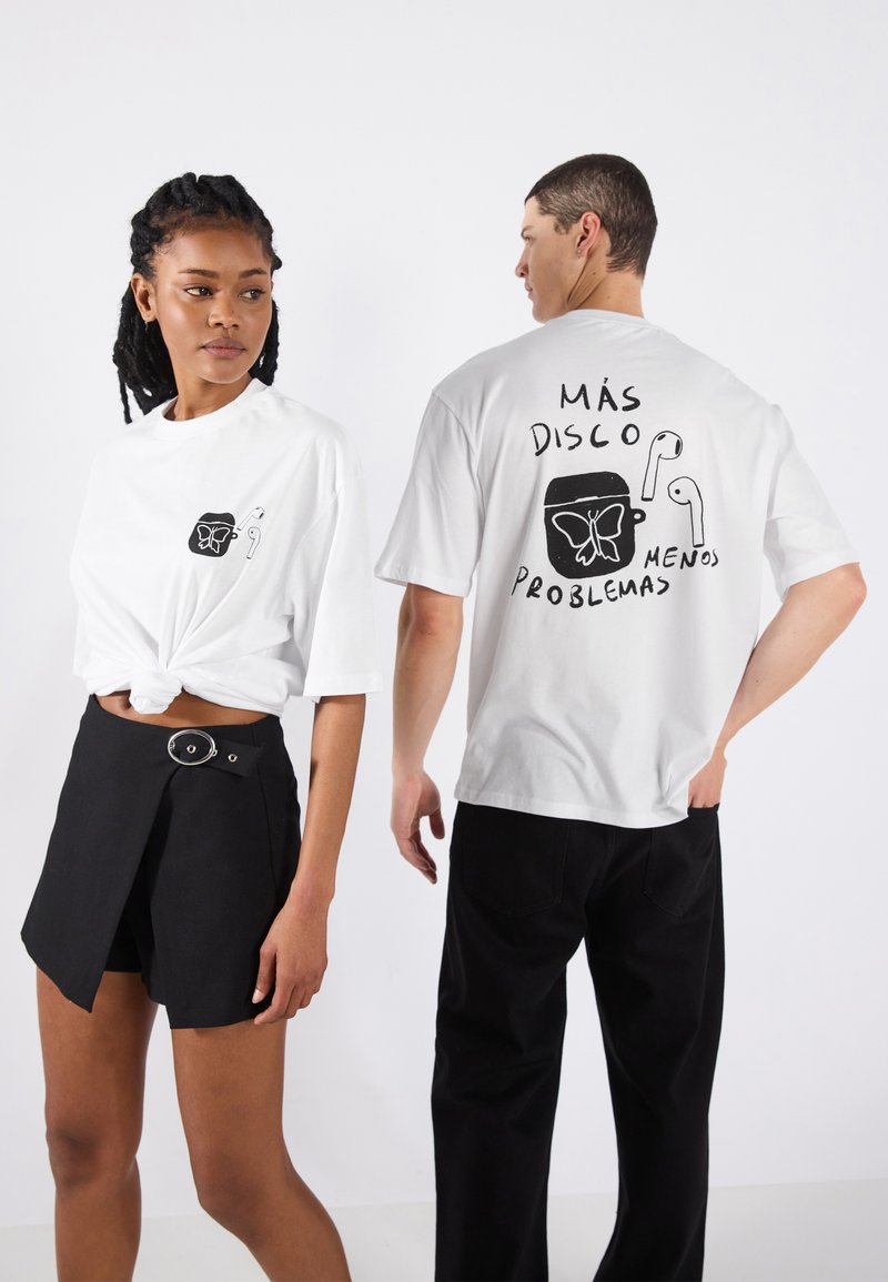 White t-shirt with a graphic print of a butterfly and headphones on the back. Front has a small logo. Loose fit and short sleeves.
