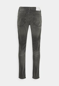 Jeans grigi slim-fit con lavaggio sbiadito, design a cinque tasche e cuciture a contrasto. Presenta una vita piatta con passante per cintura.