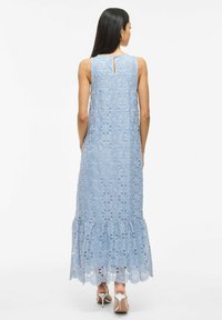 Light blue lace maxi dress with floral patterns, sleeveless design, ruffled hemline, and keyhole back detail.  Wear with heeled sandals.