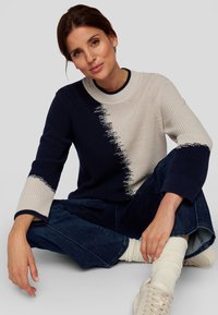 Strickpullover mit einem Farbblockdesign in Marineblau und Beige, strukturiertem Rippenstoff und drei Viertel langen Ärmeln.