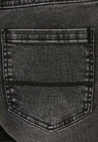 Tela de mezclilla negra con un bolsillo trasero que tiene un diseño cosido. La textura está ligeramente desgastada con un acabado suave y un desvanecimiento sutil.