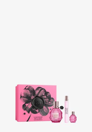 Bloemen-geïnspireerde geschenkdoos in felroze, met een grote zwarte bloemillustratie, met drie roze glazen parfumflesjes in verschillende maten.