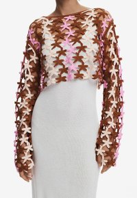 Brun og lyserød blomsteret crochtop med lange ærmer, lagdelt over et tætsiddende, hvidt stofplagg. Struktureret design.