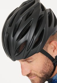 Sort cykelhjelm med aerodynamisk design, flere luftventiler og mat overflade. Justerbar rem for sikker pasform. Nærbillede.